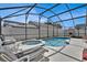 Backyard pool and spa area with screened enclosure and patio furniture at 2515 La Jolla Trl, Kissimmee, FL 34747