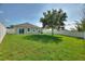Expansive green backyard with a white vinyl fence and sliding glass doors for easy indoor-outdoor living at 264 Milestone Dr, Haines City, FL 33844