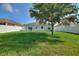 Well maintained backyard with lush lawn, white fencing and mature shade tree at 264 Milestone Dr, Haines City, FL 33844