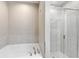 Bright bathroom featuring a soaking tub, a glass-enclosed shower, and tiled walls at 264 Milestone Dr, Haines City, FL 33844
