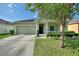 Beautiful single-Gathering home with a well-maintained lawn, complemented by lush green shrubbery at 264 Milestone Dr, Haines City, FL 33844