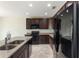 Well-equipped kitchen with stainless steel appliances, dark cabinets, and island sink at 264 Milestone Dr, Haines City, FL 33844