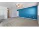 Spacious living room featuring plush carpeting, a ceiling fan, and a vibrant blue accent wall at 264 Milestone Dr, Haines City, FL 33844