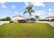 The backyard features a large grassy area, a screened-in pool and is surrounded by a white vinyl privacy fence at 2725 White Magnolia Loop, Clermont, FL 34711