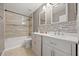 Bathroom featuring a tub and shower, dual sinks, and mosaic tile accents at 2725 White Magnolia Loop, Clermont, FL 34711