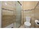 Modern bathroom with tiled walls, glass-enclosed shower, and sleek toilet for a spa-like experience at 2725 White Magnolia Loop, Clermont, FL 34711