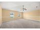 Large empty bedroom, featuring carpet, ceiling fan and large windows at 2725 White Magnolia Loop, Clermont, FL 34711
