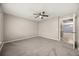 Spacious bedroom featuring neutral carpet, ceiling fan and access to ensuite bathroom at 2725 White Magnolia Loop, Clermont, FL 34711