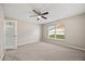 Empty bedroom featuring carpet, a ceiling fan, and a window overlooking a backyard at 2725 White Magnolia Loop, Clermont, FL 34711