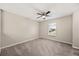 A cozy bedroom featuring a ceiling fan, neutral walls, plush carpet, and a bright window view at 2725 White Magnolia Loop, Clermont, FL 34711