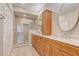Well-appointed bathroom with dual sinks, wooden cabinets, and a spacious glass-enclosed shower at 2763 Metro Sevilla Dr # 103, Orlando, FL 32835