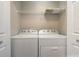 Laundry area with white washer and dryer units under a wire rack at 2763 Metro Sevilla Dr # 103, Orlando, FL 32835
