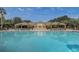 Large community pool with ample seating in front of a well-maintained clubhouse at 2763 Metro Sevilla Dr # 103, Orlando, FL 32835