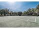 Well maintained community tennis court under a clear blue sky, surrounded by mature trees at 2763 Metro Sevilla Dr # 103, Orlando, FL 32835