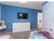 Blue themed bedroom featuring wall art, a TV and drawers for storage at 2816 Simile St, Kissimmee, FL 34746