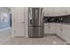 Contemporary kitchen highlighting stainless refrigerator, white cabinetry, tile flooring and backsplash at 2816 Simile St, Kissimmee, FL 34746