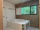 Bathroom features a large soaking tub with mosaic-style wall tiles and a scenic window at 304 Spring Run Cir, Longwood, FL 32779