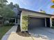 Exterior shot of a single-Gathering home featuring a two-car garage, manicured bushes, and landscaping at 304 Spring Run Cir, Longwood, FL 32779