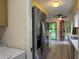 Kitchen features stainless steel refrigerator and an adjacent laundry room with washer and dryer at 304 Spring Run Cir, Longwood, FL 32779