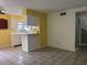 Eat-in kitchen with breakfast bar, tile floors, white cabinets, and bright yellow accent wall at 304 Spring Run Cir, Longwood, FL 32779