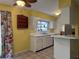 Kitchen features white cabinets, tile floor, window over sink, and bright yellow accent wall at 304 Spring Run Cir, Longwood, FL 32779