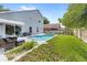 Backyard featuring a patio set and a pool surrounded by green grass and a wooden fence at 38 Jett Loop, Apopka, FL 32712
