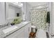 Bright bathroom featuring double sinks, granite countertops, and a shower with a floral shower curtain at 38 Jett Loop, Apopka, FL 32712