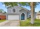 Charming two-story home with a two-car garage, blue door, and well-maintained lawn at 38 Jett Loop, Apopka, FL 32712