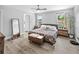 Neutral main bedroom featuring two windows, wood-look floors, stylish decor, and a walk in closet at 38 Jett Loop, Apopka, FL 32712