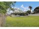 Expansive backyard with well-maintained lawn, complemented by a screened porch, ideal for outdoor enjoyment at 4217 Ilene Ct, Orlando, FL 32806