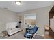 Cozy Bedroom featuring a white crib, blue rocking chair, and a window with views of the outdoors at 4217 Ilene Ct, Orlando, FL 32806