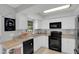 Bright kitchen featuring white cabinets and modern black appliances, with a window view at 4217 Ilene Ct, Orlando, FL 32806