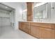 Bright bathroom with double vanities, a custom closet, and white tile floors at 4266 La Salle Ave, St Cloud, FL 34772