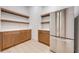 Walk-in pantry with custom wood cabinets and shelving, with stainless refrigerator at 4266 La Salle Ave, St Cloud, FL 34772