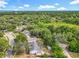An aerial view shows homes nestled in a lush, green, tree-filled landscape under a partly cloudy blue sky at 4274 Meeting Pl, Sanford, FL 32773