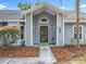 Home entrance featuring a classic door with sidelights, covered porch, and mature landscaping at 4274 Meeting Pl, Sanford, FL 32773