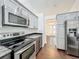 Kitchen with stainless appliances, grey cabinets, and hardwood floors at 4274 Meeting Pl, Sanford, FL 32773