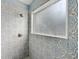 Walk-in shower featuring designer tilework, and a frosted window for natural light at 4398 Fox Hollow Cir, Casselberry, FL 32707