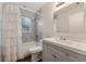 Charming bathroom featuring patterned tile, shower-tub combo, and vanity with white sink and gray cabinets at 4398 Fox Hollow Cir, Casselberry, FL 32707