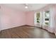 Pink bedroom with hardwood floors, large windows, and a ceiling fan at 4398 Fox Hollow Cir, Casselberry, FL 32707