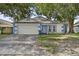 Charming single-story home with blue and white trim, a two-car garage, and a well-manicured front yard at 4398 Fox Hollow Cir, Casselberry, FL 32707