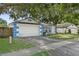 Charming one-story home featuring blue and white accents, a two-car garage, and mature landscaping at 4398 Fox Hollow Cir, Casselberry, FL 32707