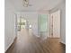 Hallway with hardwood floors leading to a living room with vaulted ceilings and sliding glass doors to the backyard at 4398 Fox Hollow Cir, Casselberry, FL 32707