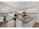 Modern kitchen with stainless steel appliances, gray backsplash, a granite countertop island, and wood-look floors at 4398 Fox Hollow Cir, Casselberry, FL 32707