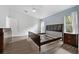 Bright main bedroom with wood-look floors, two windows, and an ensuite bathroom at 4398 Fox Hollow Cir, Casselberry, FL 32707