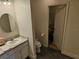 Cozy bathroom with white vanity, a round mirror, and an open door revealing a walk-in closet at 4564 Orchard Grove Rd, St Cloud, FL 34772