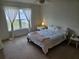 Bright bedroom with plush carpet features a large window with flowing sheer curtains and neutral decor at 4564 Orchard Grove Rd, St Cloud, FL 34772