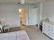 Bedroom view highlights ensuite bathroom access and a bright window, complemented by neutral paint and carpet at 4564 Orchard Grove Rd, St Cloud, FL 34772