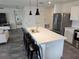 Modern kitchen boasts stainless steel appliances, large island with pendant lighting, and stylish gray tile floors at 4564 Orchard Grove Rd, St Cloud, FL 34772