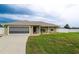 Beautiful home exterior featuring a well-kept lawn, attractive landscaping, and an attached garage at 6011 Country Walk Ln, Winter Haven, FL 33880